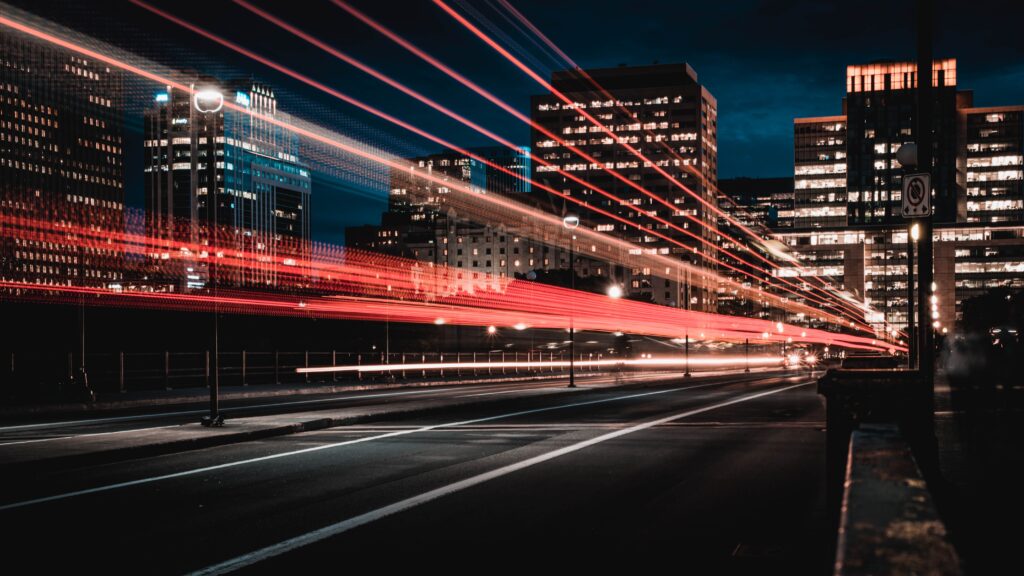 Red lights moving fast over city buildings at night