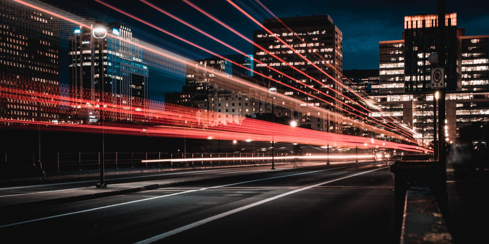 Red lights moving fast over city buildings at night