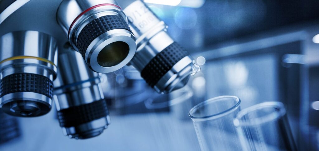 Microscope lenses over test tubes in a research laboratory.