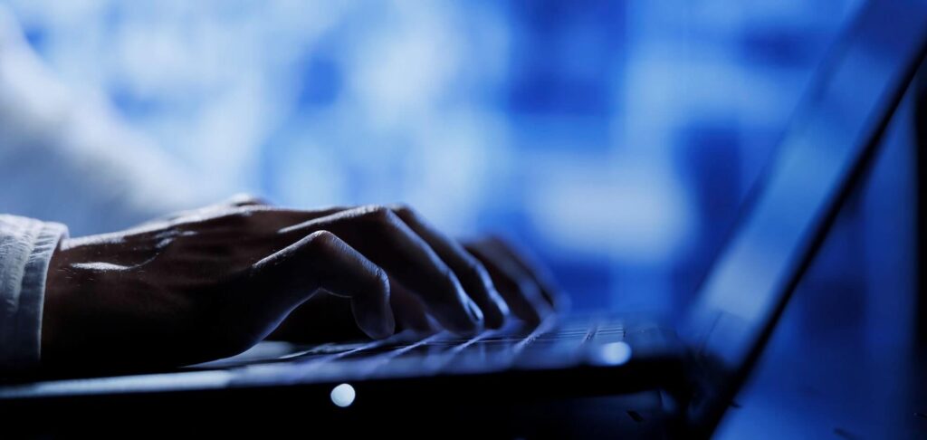 Professional working on a laptop symbolizing the Head of Consumer Research and Analysis role across Germany and EMEA