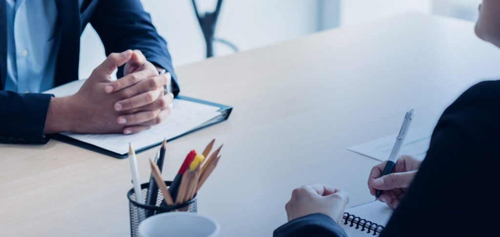 Two professionals in conversation at a meeting table, representing effective interview communication.