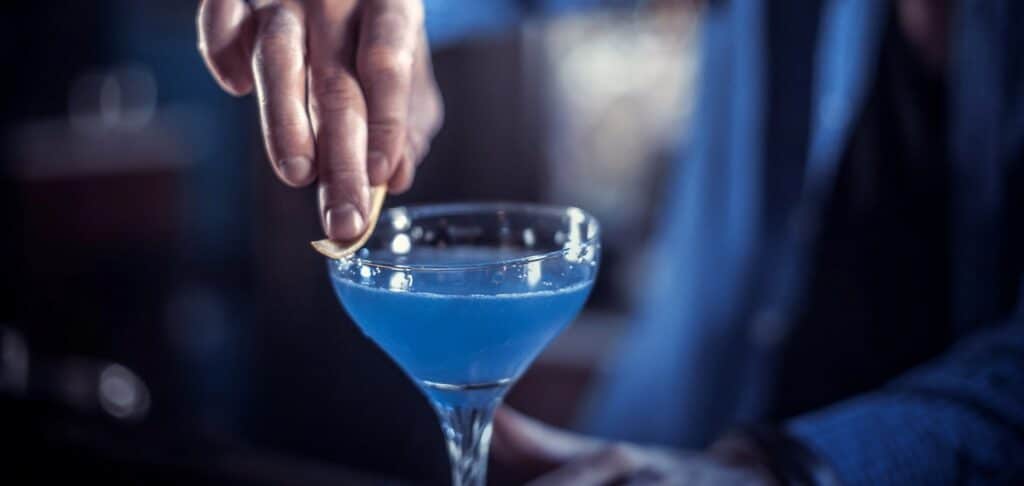 Hand serving a cocktail in a bar, symbolising financial leadership in a private equity-backed hospitality company.