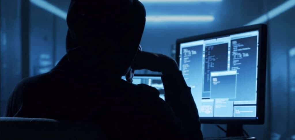 Person working on computer screens, symbolising cyber-security awareness and demand.
