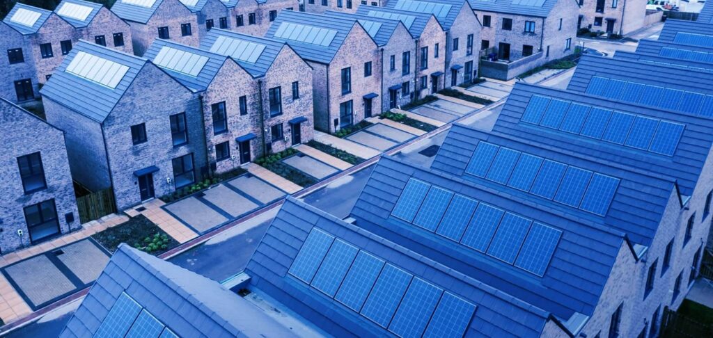 Row of new residential houses with solar panels, symbolising the evolution of UK housing.