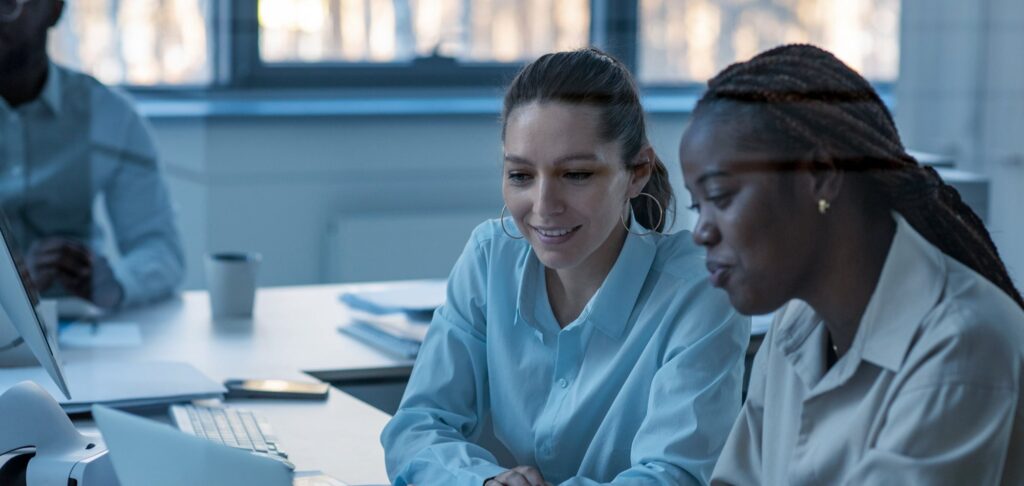 Two women collaborating in an office, representing the importance of DE&I staff retention.