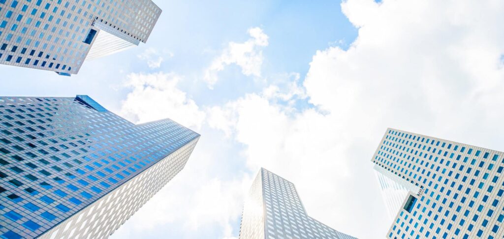 Low-angle view of modern office buildings, representing board-level appointments in asset management.