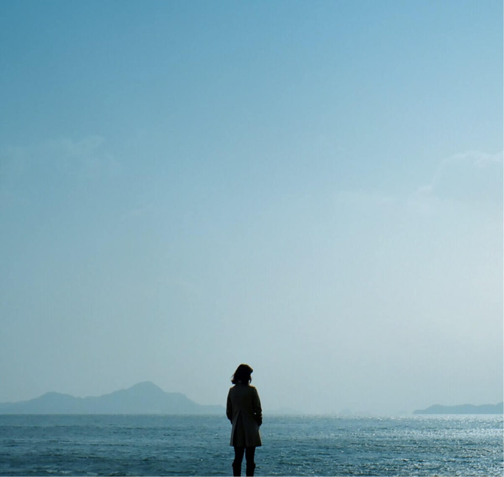 Professional standing by the sea symbolizing McLean Partnership’s transparent and ethical recruitment approach.